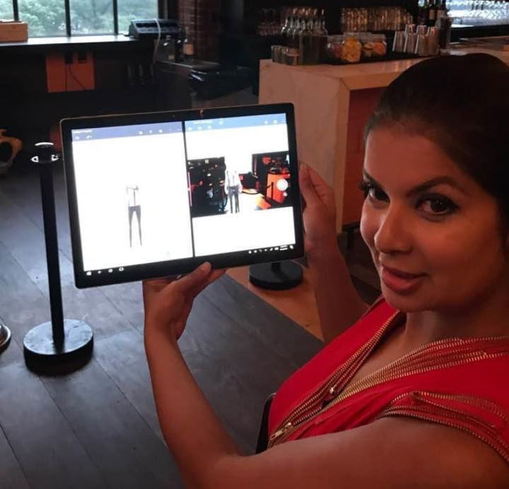 Dona holding a Surface tablet showing a 3D sketch of a fashion model and then showing  placed in the room 