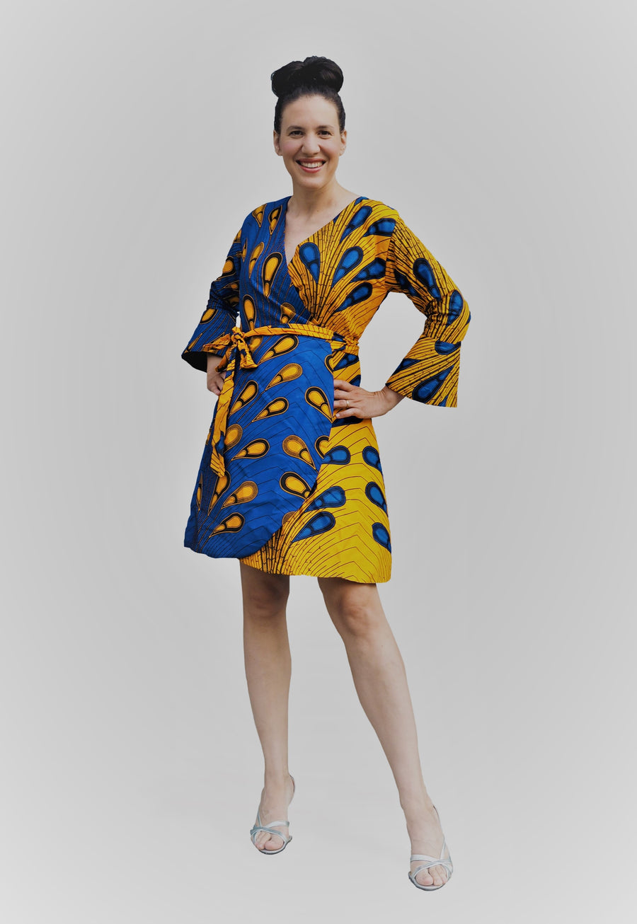 Wrap-dress made with gold fabric with blue accents and the opposite side blue fabric with gold accents. 