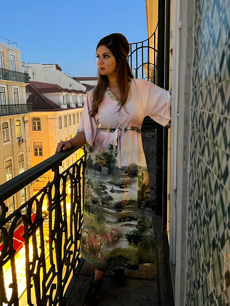 White silk caftan-dress with a cinched waist with a print of a seaside town in the waist and down
